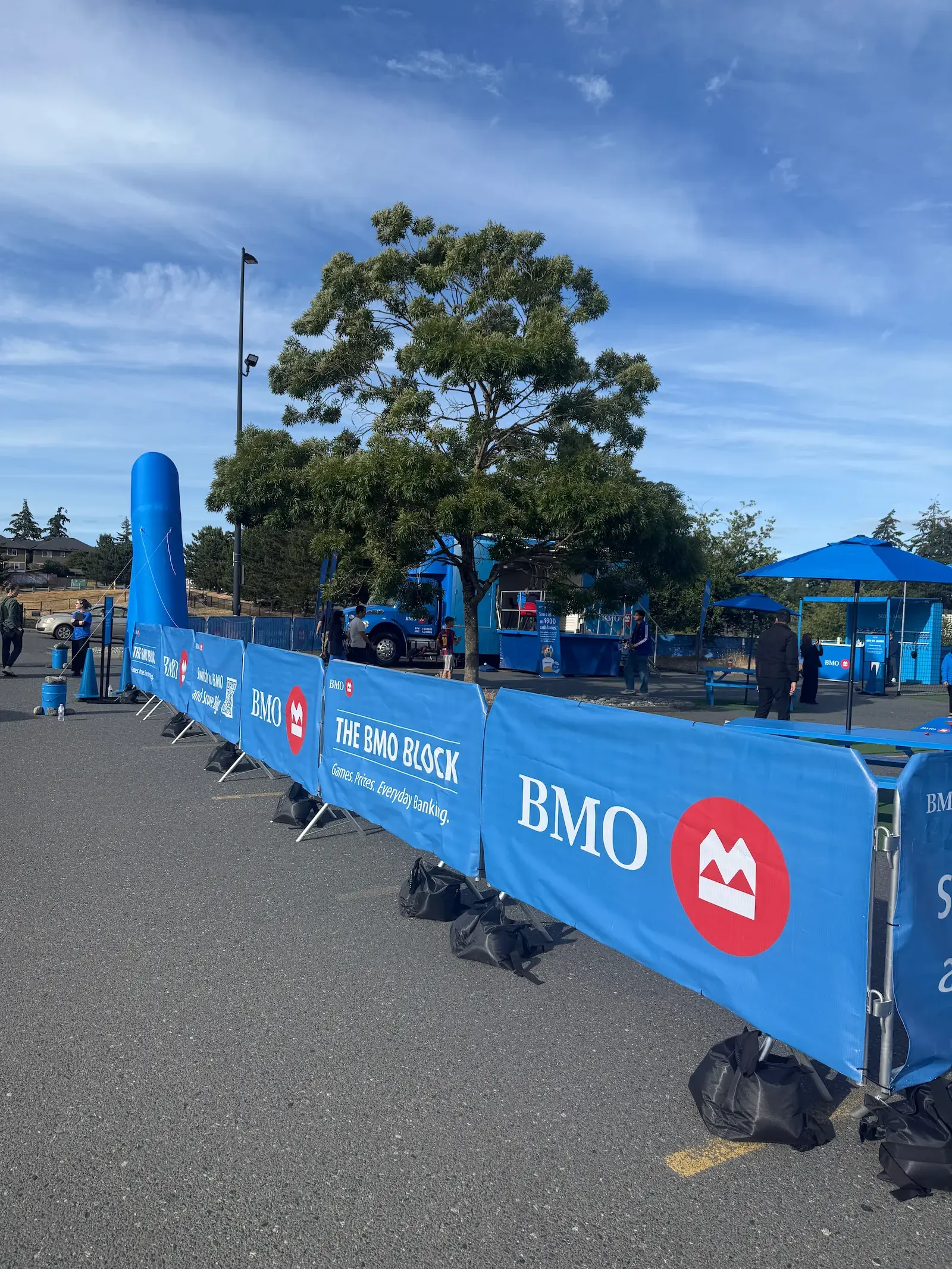 Steel barricades wrapped in branded event signage, linked into a continuous line at a corporate activation.