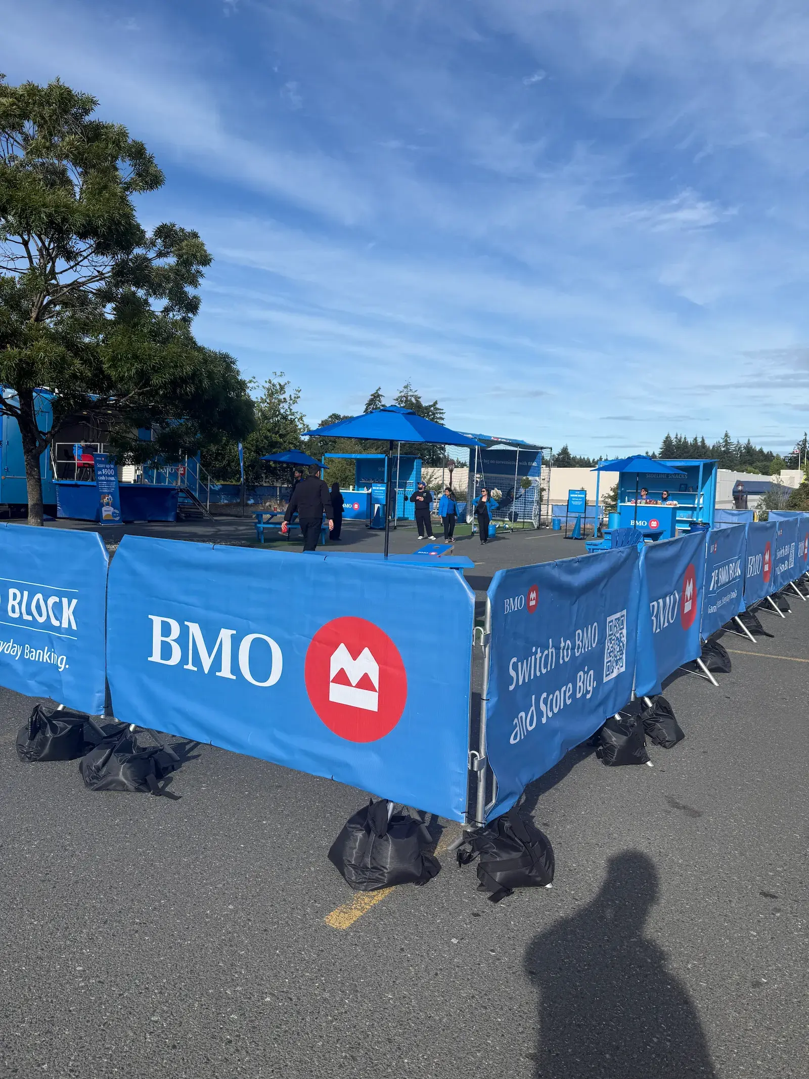 Branded steel barricades forming a perimeter at an outdoor activation.