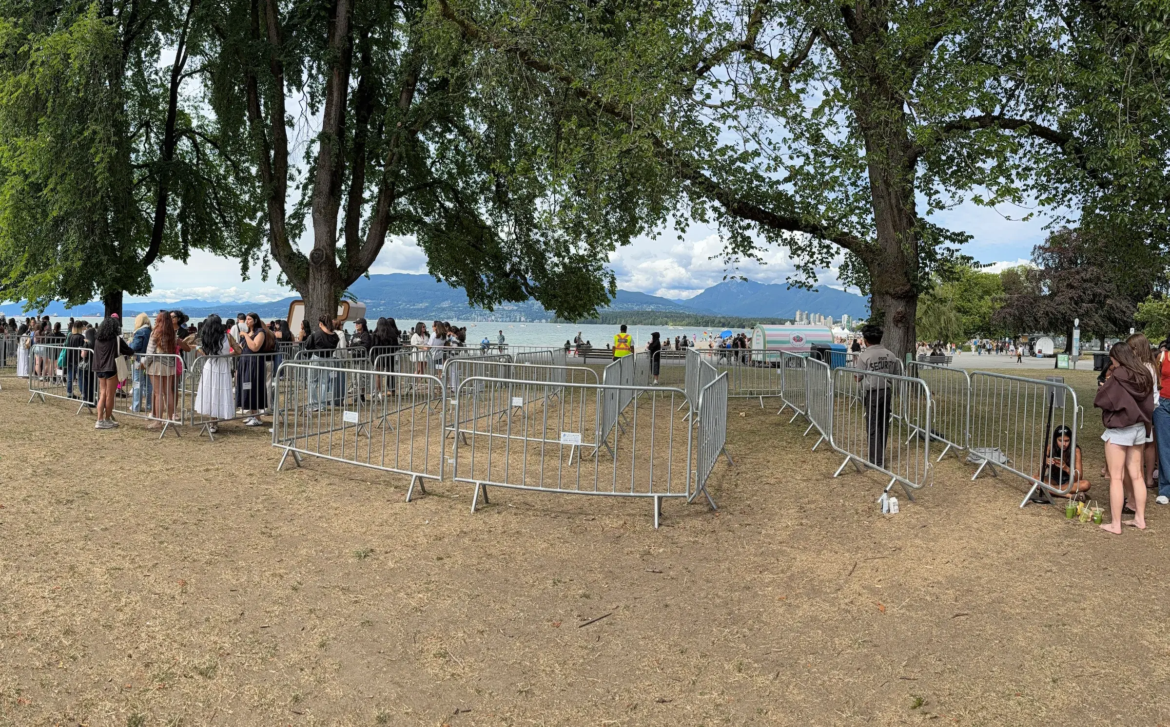 Galvanized barricades linked into a continuous line at an outdoor waterfront event