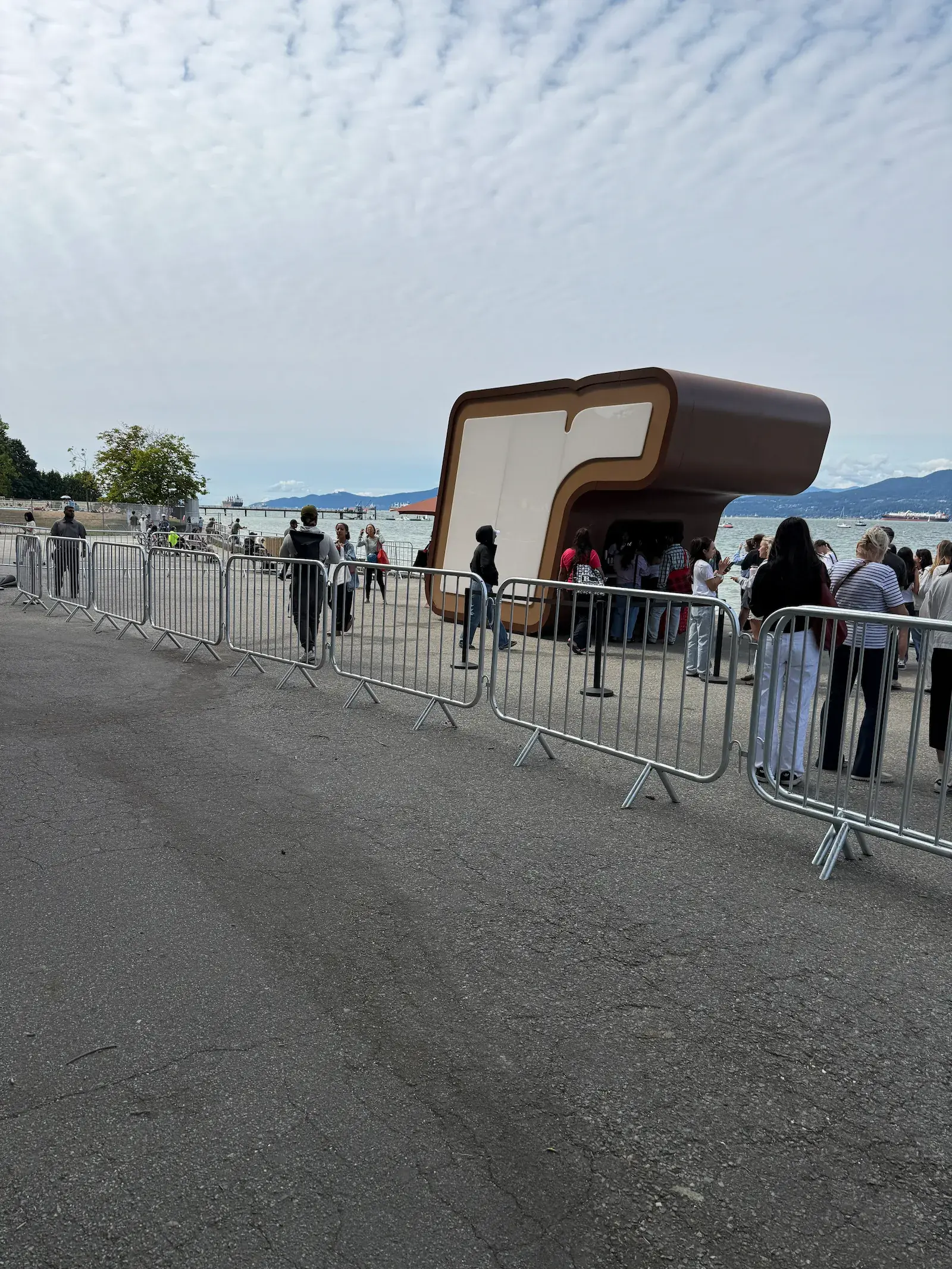 Crowd control barriers forming a line near the water at an outdoor event.