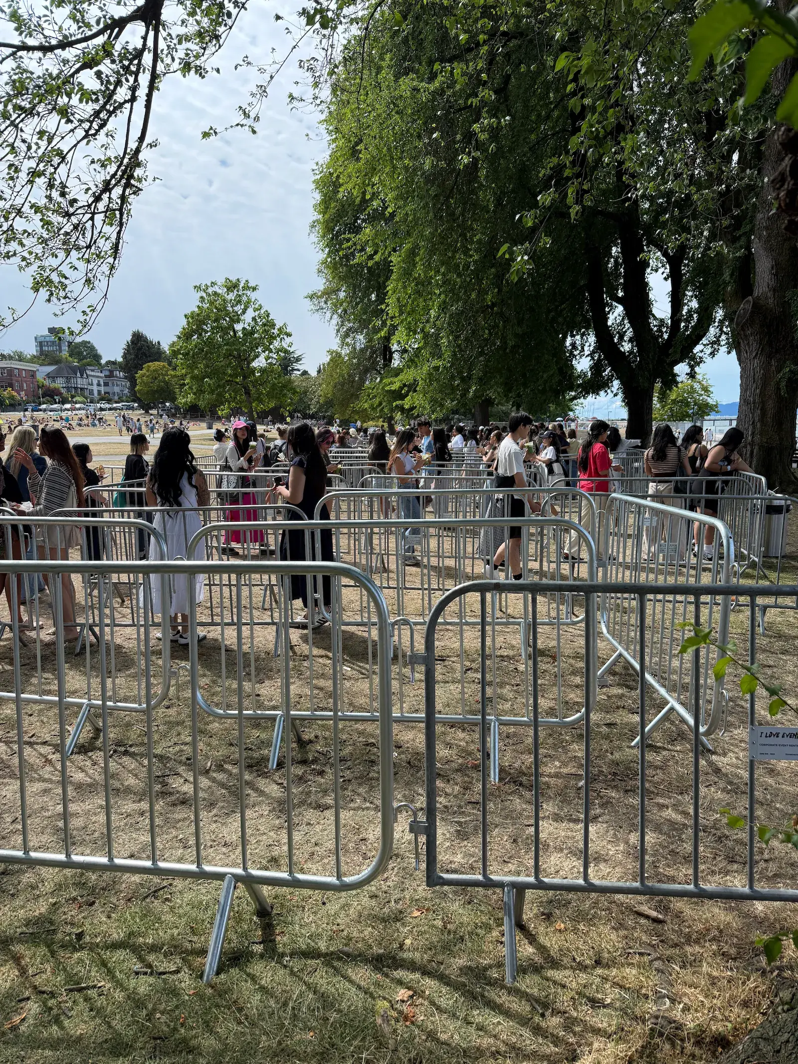 Steel barricades lining a grassy area at an outdoor event.